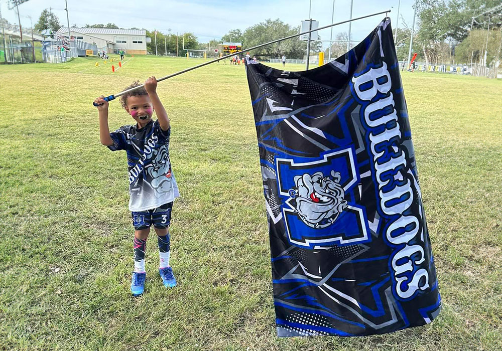 Young athlete with team flag wearing D.L. Customs gear